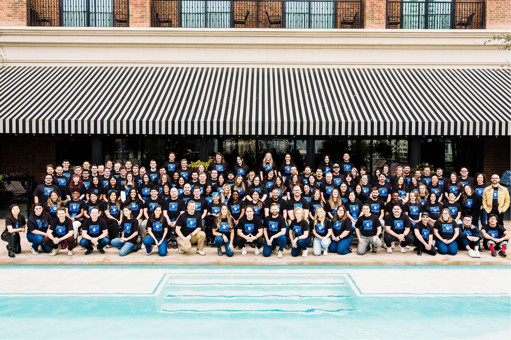 Group photo of the CertifID team standing and kneeling outside a modern building